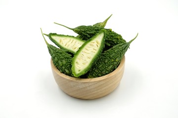 Bitter gourd in wooden bowl on white background