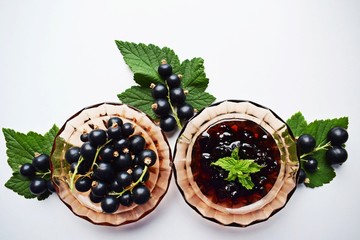 Ripe,sweet black currant and tasty jam on white background.