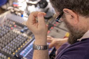 Sound engineer behind the sound mixing console controls the sound