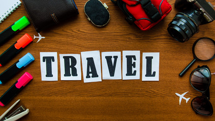 Travel word letters inscription wooden table top view. Preparation for the vacation adventures...