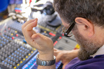 Sound engineer behind the sound mixing console controls the sound