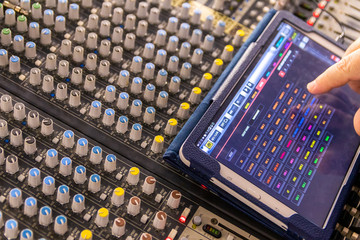 Sound engineer behind the sound mixing console controls the sound