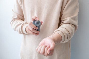 Men are spraying perfume on his wrist.