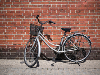 Fototapeta na wymiar Bicycle on Roadside with Brick Wall Background