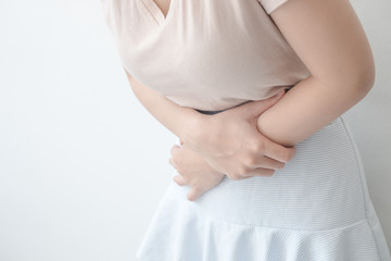 Women with abdominal pain standing, holding the body and hands Photos, concepts of health and medical care