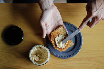 Mano untando pan tostado 