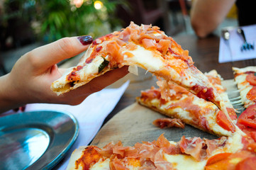 Mujer tomando rebanada de pizza 