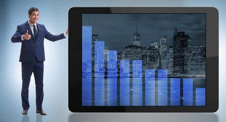 Fototapeta premium Businessman standing next to tablet computer in business concept