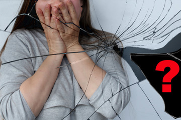 girl with long hairs covered her face with her hands, a reflection in a mirror broken into fragments, a problem concept, a question mark on a fragment