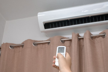 Focus ahead.Air condition control by using remote control and turn on the air conditioner at 25...