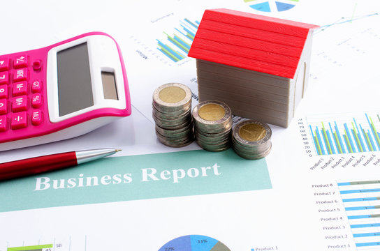 Close up of money coin stack with red house and pen pink calculator for business finnance concept