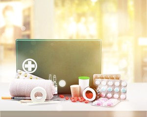 First aid kit  with medical supplies on light background