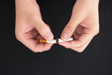 Quit smoking,hand hold cigarette destroy isolated on black background.