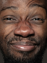 Close up portrait of young and emotional african-american man. Highly detail photoshot of male model with well-kept skin and bright facial expression. Concept of human emotions. Happy grimaces.