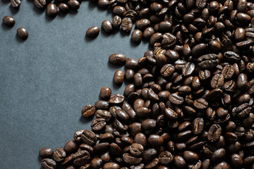 Brown roasted coffee beans, seed on dark background.