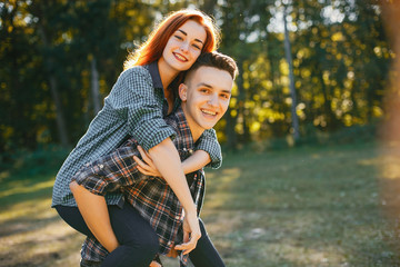 Fototapeta premium Cute couple in a park. Lady with red hair.