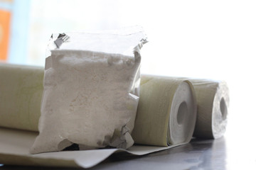 The glue in the package and a roll of Wallpaper