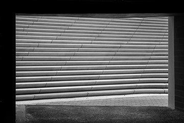 Concrete stairs behind a passage opening. Black and white photography.