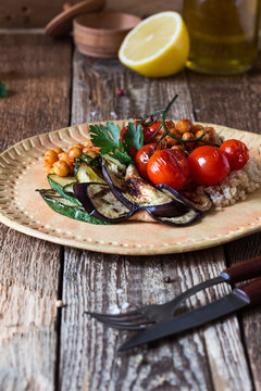 Healthy vegan meal, grilled cherry tomatoes, eggplant, zucchini, quinoa, roasted chickpeas