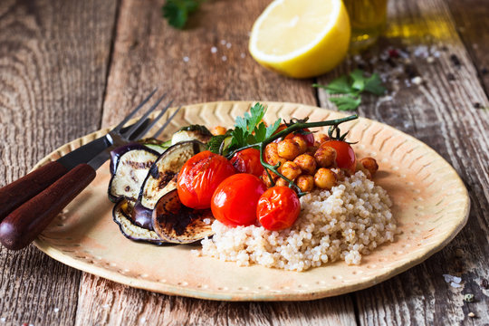 Healthy vegan meal, grilled cherry tomatoes, eggplant, zucchini, quinoa, roasted chickpeas