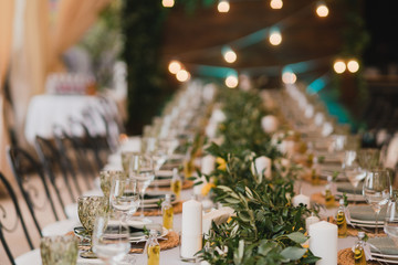 Coziness and style. Modern event design. Table setting at wedding reception. Floral compositions...
