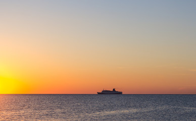 Naklejka na ściany i meble Silhouette of a tourist ship at sunset