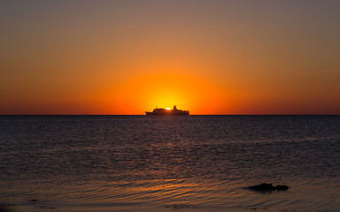 Obraz na płótnie Canvas Silhouette of a tourist ship at sunset