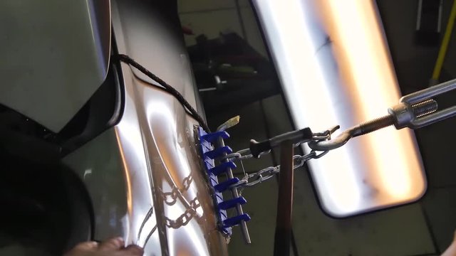 Paintless Dent Repair Removal. Tap Down Tools Dent Rubber Hammer Auto Body. The guy knocks with a hammer on the car to align the dent on technology PDR.