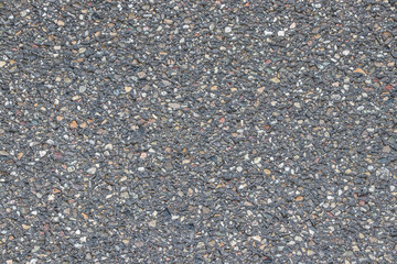 The grey texture of road cover with colorful elements.