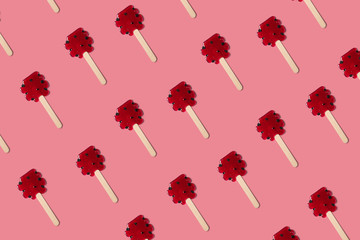 Red candy sweet pattern on the pink minimal background. Lollipops flatlay top view