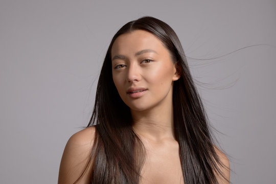 beauty brunette model mixed race model with long strong straight hair blowing. Ideal skin natural makeup