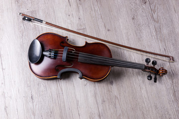 Naklejka na ściany i meble Classical violin isolated on wooden background. Studio shot of old violin. Classical musical instrument