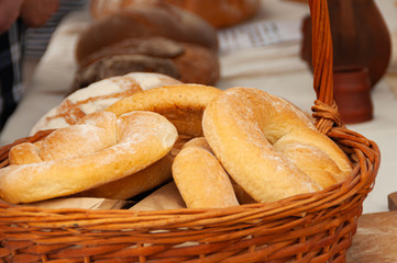 Basket stands on the table, in the basket of bread. Fresh bread. In the background, other types of bread.