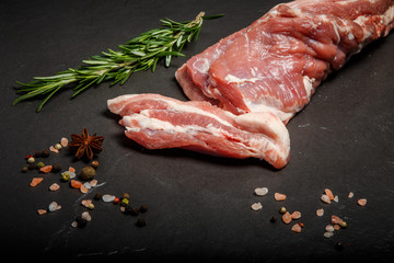 top view on raw meat with sliced piece with green rosemary
