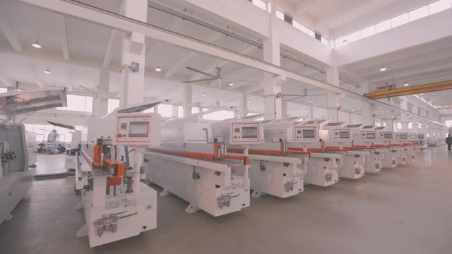 Manufactured woodworking machines stand in a row in stock. A large factory for the production of automated machine tools. Warehouse of woodworking machines