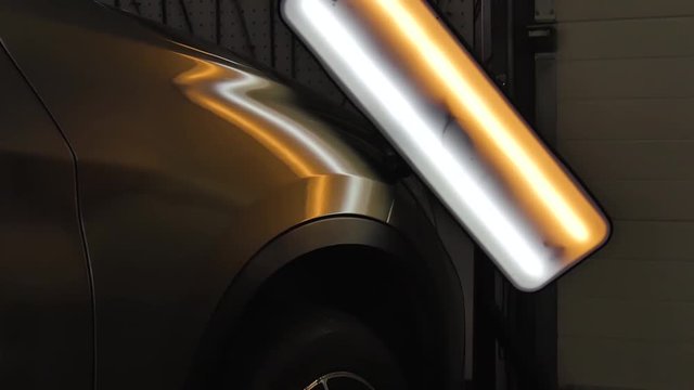 The ideal surface of the car after a collision, PDR technology, close up under the headlamp, professionalism, dents leveling service. Paintless Dent Repair Removal