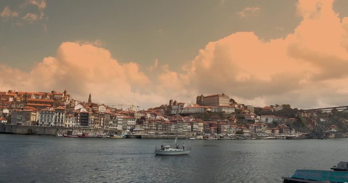 Portugal,  Porto, old city centre, beautiful sky with pink fluffy clouds, and boats on the Douro river, timelapse