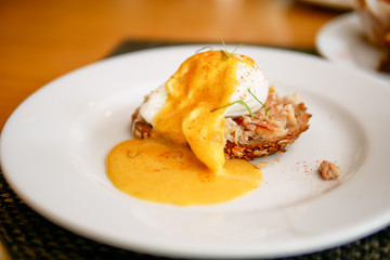 Delicious breakfast or morning food with eggs Benedict and and juice that placed on the wooden table