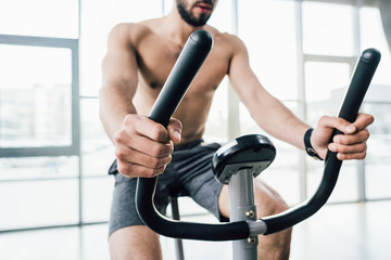 Fototapeta na wymiar partial view of sportsman training on elliptical machine at gym