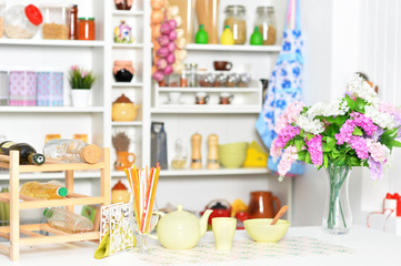 Yellow tableware and flowers on a kitchen table