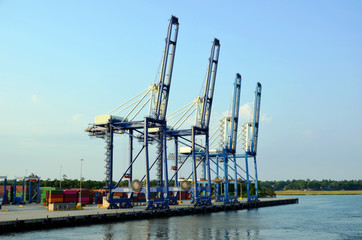 Gantry cranes are loading cargo on the container ship in port of Charleston, South Carolina.  