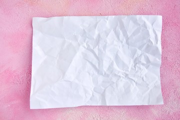 crumpled paper on pink plaster background for design banner or card, selective focus. Clear...