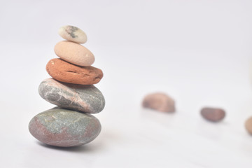 Fototapeta na wymiar zen symbol, relaxing colorful stones with white background
