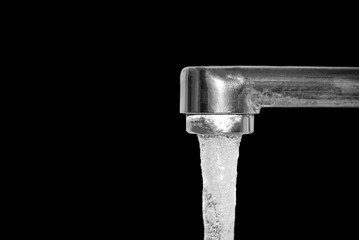 open running water tap isolated on black