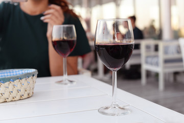 a glasses with a red  of  champagne wine at dinner, raising drink  a toast in a  beautiful restaurant