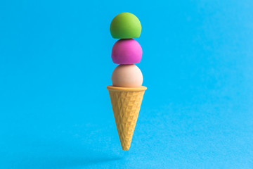 Scoops in ice cream cone abstract isolated on blue.