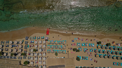 Aerial drone photo of famous organised with sun beds and umbrellas beach of  Paradise with emerald clear sandy sea shore, Mykonos island, Cyclades, Greece  