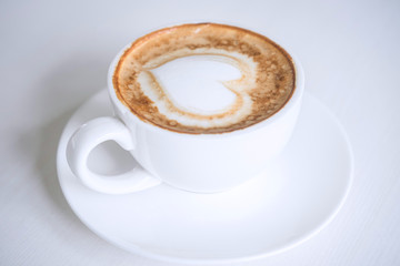 White Cup of coffee with milk foam so delicious on white wooden table texture