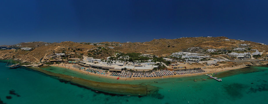 Aerial drone photo of famous organised with sun beds and umbrellas beach of  Paradise with emerald clear sandy sea shore, Mykonos island, Cyclades, Greece  