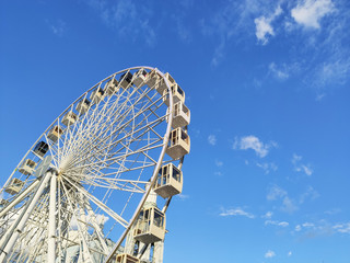white ferris wheel amusement for entertainment against a blue sky